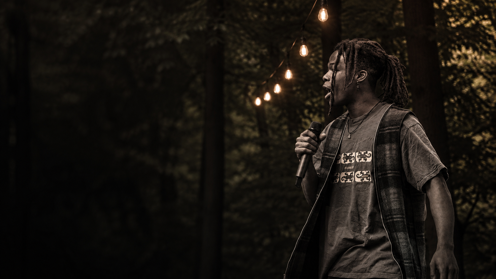 Ok Tav performing outdoors under string lights in Kalamazoo, Michigan